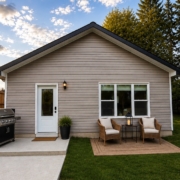 Real detached two-bedroom coach home (ADU) built by Visture Property Group in a Peterborough backyard, shown at dusk with patio seating