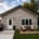 Real detached two-bedroom coach home (ADU) built by Visture Property Group in a Peterborough backyard, shown at dusk with patio seating