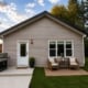 Real detached two-bedroom coach home (ADU) built by Visture Property Group in a Peterborough backyard, shown at dusk with patio seating