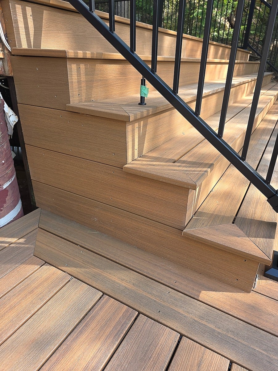 Finished composite deck stairs with black railing installed by Visture